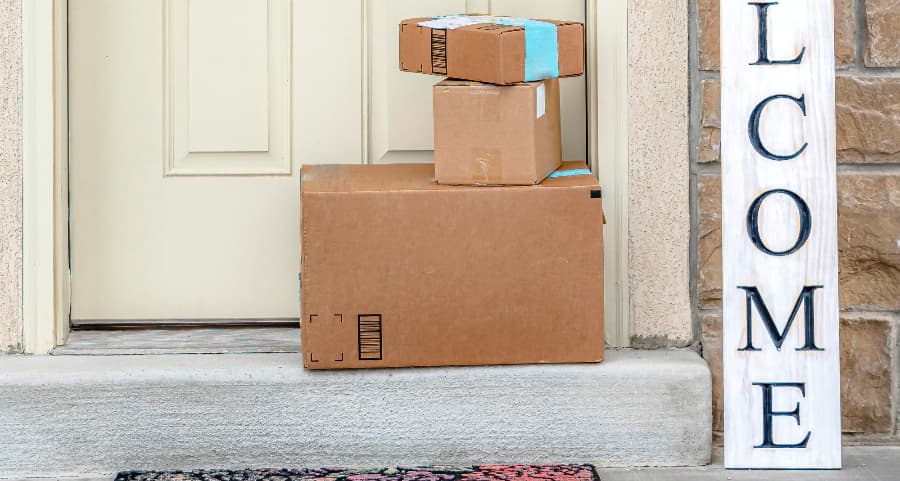 Boxes by the door of a residence with a welcome sign in Orange County